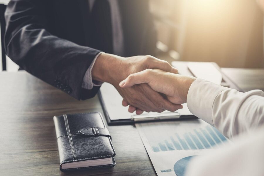 Financial advisor and client shaking hands over a business agreement